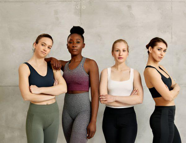 Portrait of confident diverse female athletes against the wall