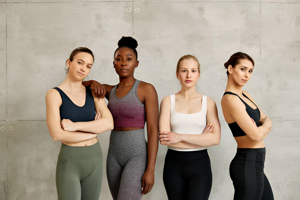 Portrait of confident diverse female athletes against the wall